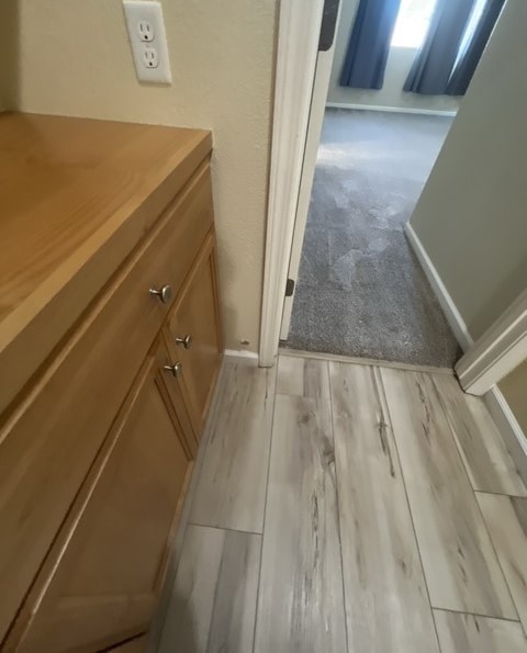 a bathroom with wood flooring and a door to a hallway