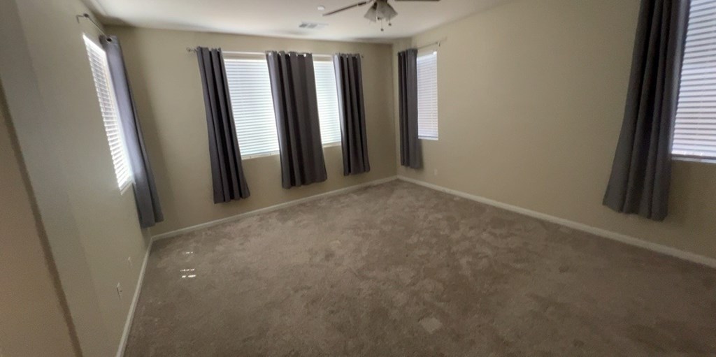 an empty living room with windows and curtains