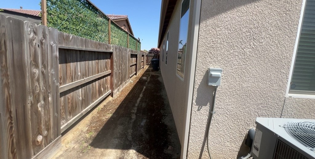 the side of a house with a fence and a power line