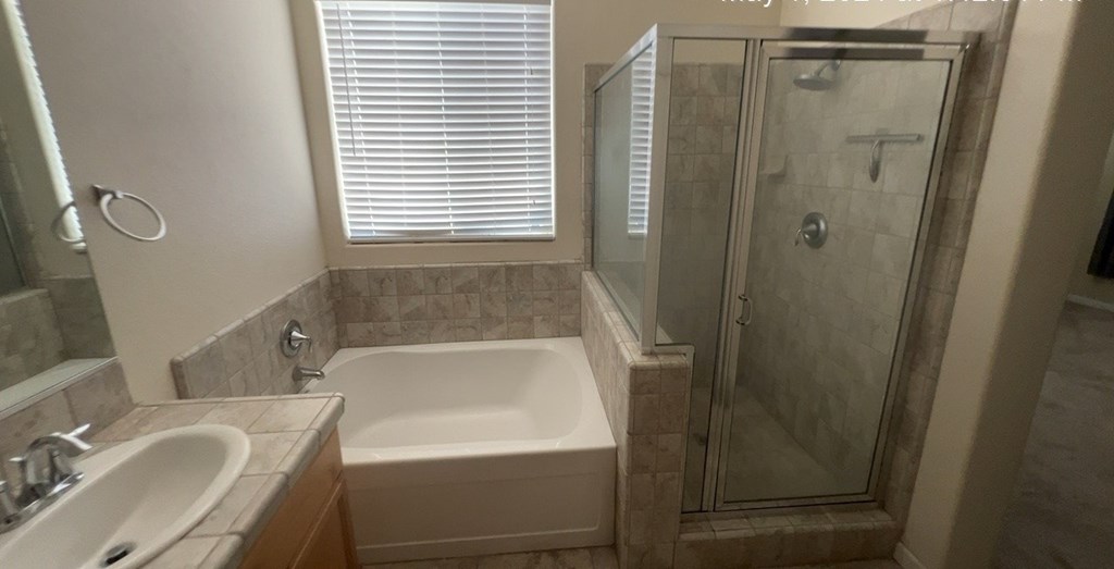 a bathroom with a tub and a shower and a sink