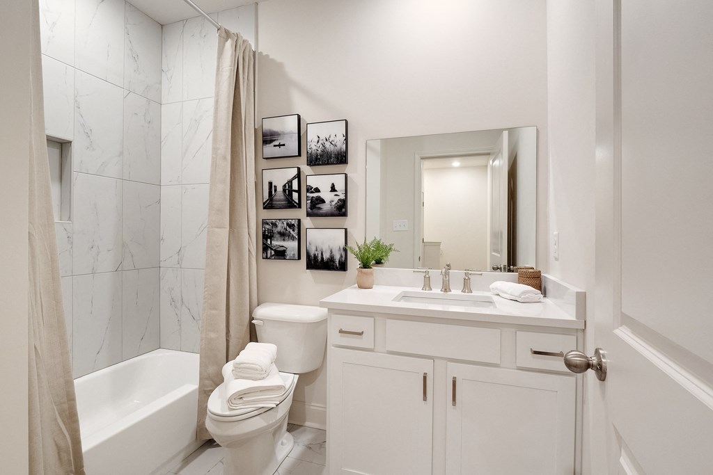 a white bathroom with a shower toilet and sink