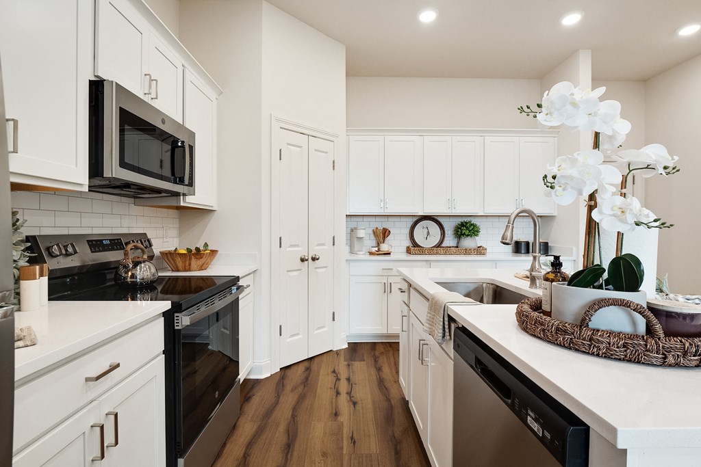 a white kitchen with stainless steel appliances and white cabinets