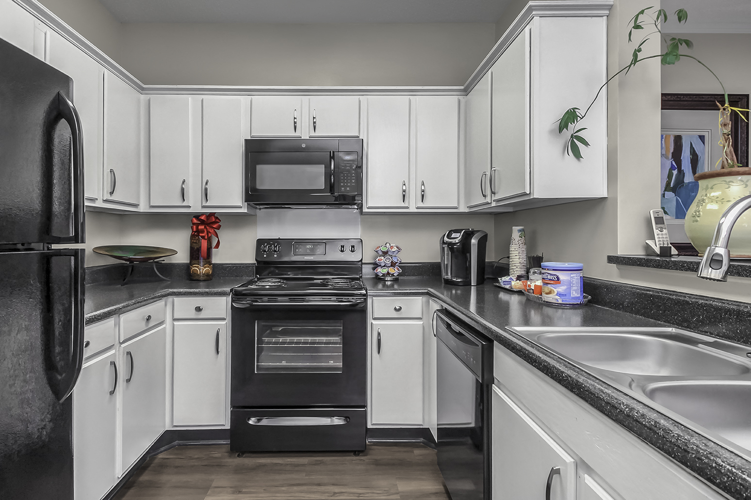 a kitchen with black appliances and white cabinets