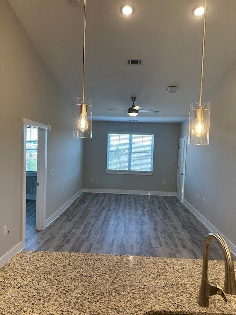 an empty living room with two hanging lights