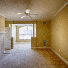 an empty living room with a ceiling fan