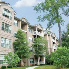 an apartment building with trees in front of it