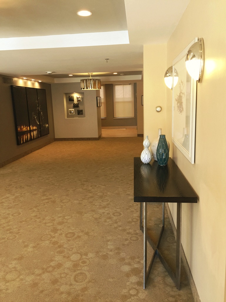 a hallway with a table and a mirror in a hotel room
