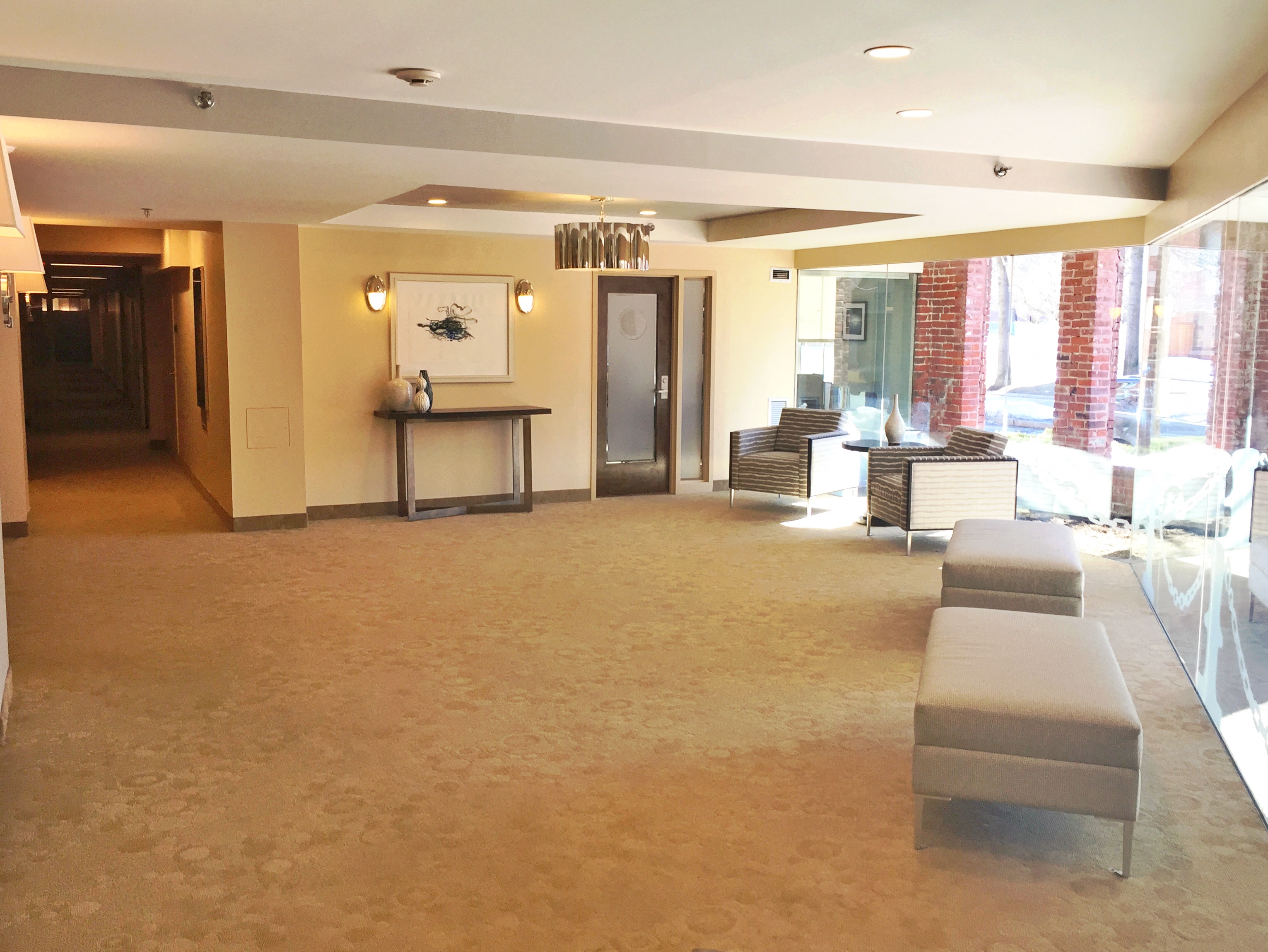 the lobby of a hotel with seating and a reception desk