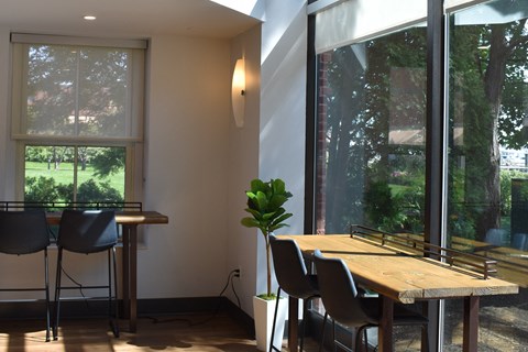 a dining room with large windows and a wooden table and chairs