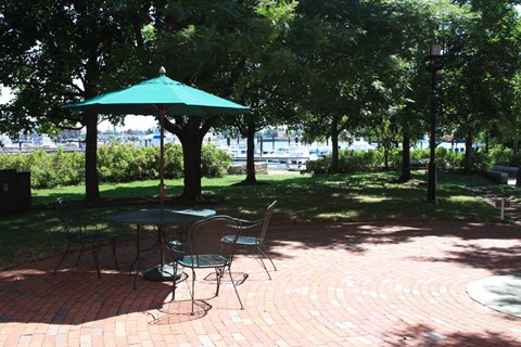 a picnic area in a park with a table and umbrella