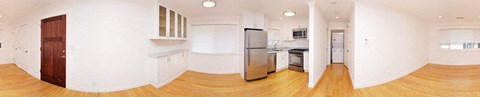 an empty kitchen with white walls and a refrigerator