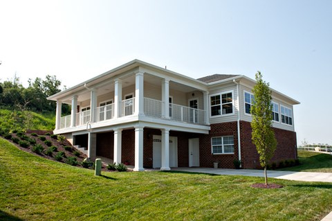 the front of a house with a porch and a lawn