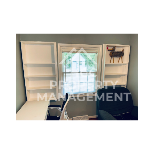 a small office with a desk and a window