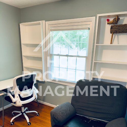 a small office with a chair and a window