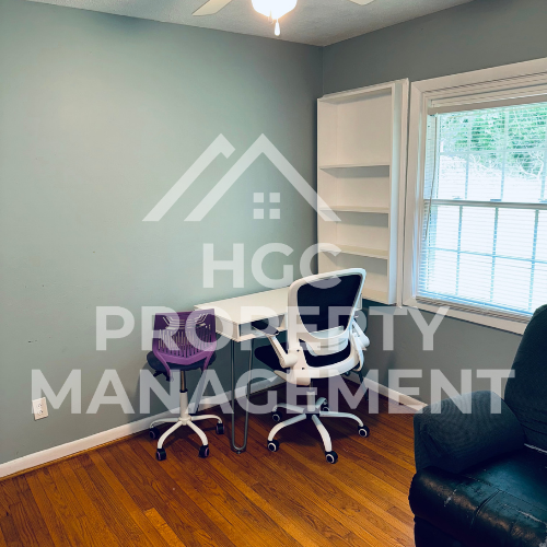 a home office with a chair and a desk and a window