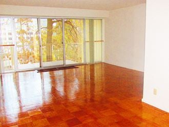an empty living room with a wood floor and a window