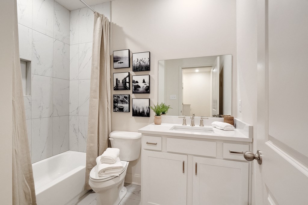 a white bathroom with a shower toilet and sink