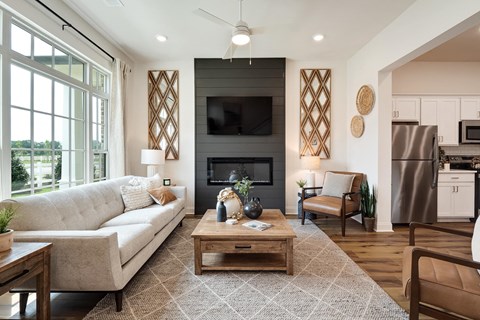 a living room with a couch and a table in front of a fireplace