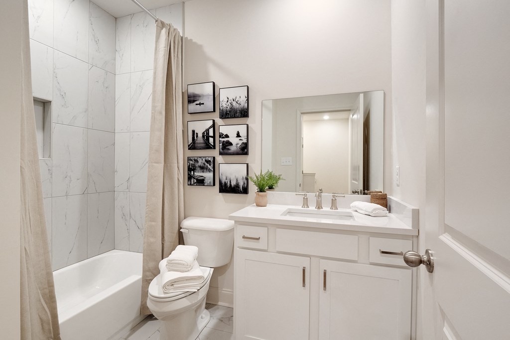 a white bathroom with a shower toilet and sink
