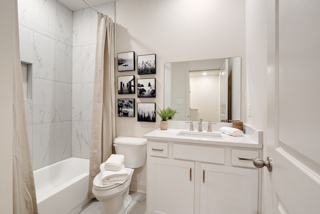 a white bathroom with a shower toilet and sink