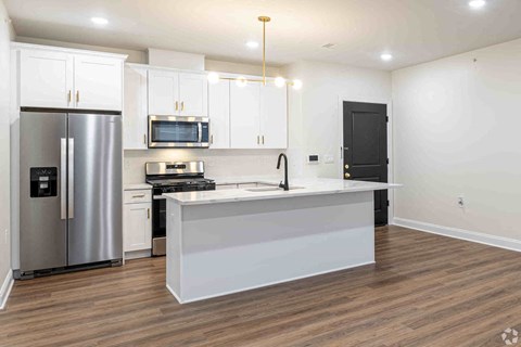 a kitchen with a large island and a stainless steel refrigerator