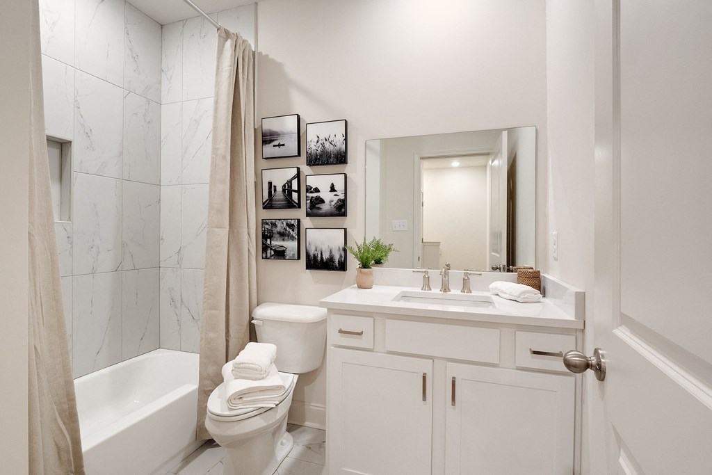 a white bathroom with a shower toilet and sink