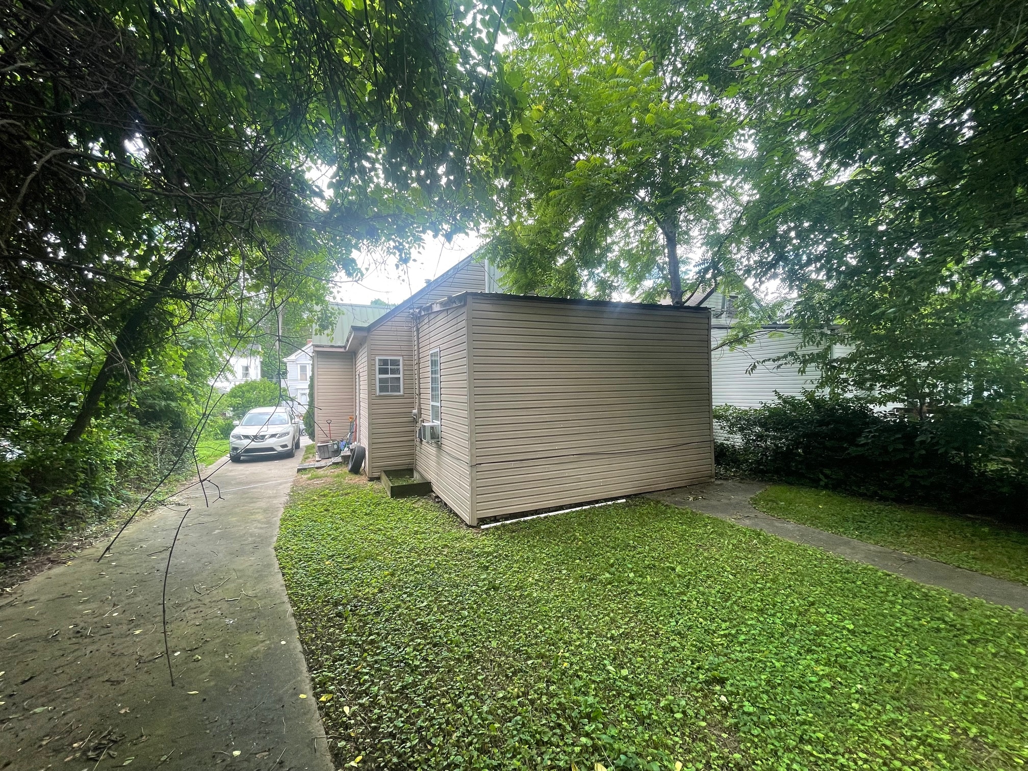 a small house on the side of a sidewalk