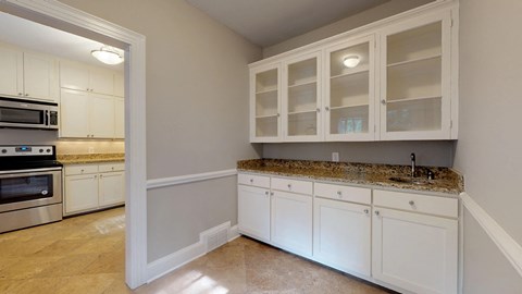 A kitchen with white cabinets and granite countertops.