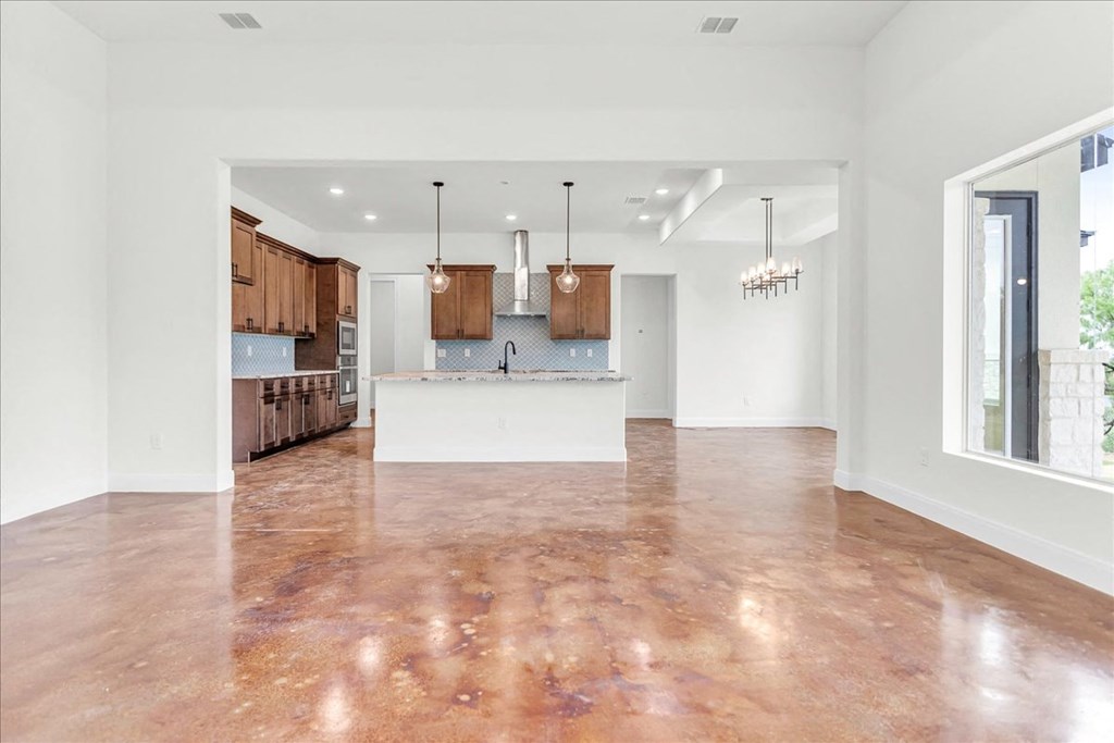 an empty kitchen and living room with a large window
