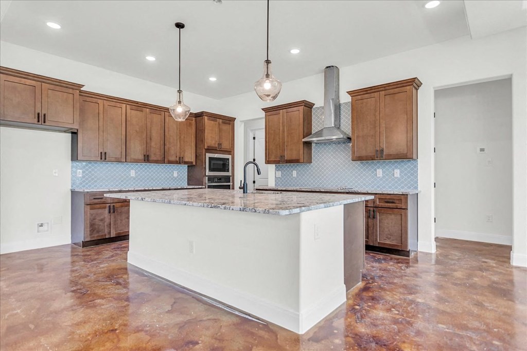 a large kitchen with an island and wooden cabinets