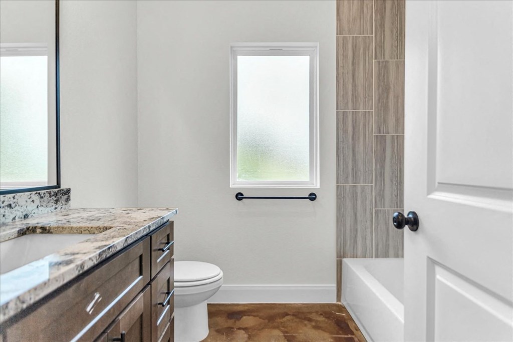 a bathroom with a toilet and a tub and a sink