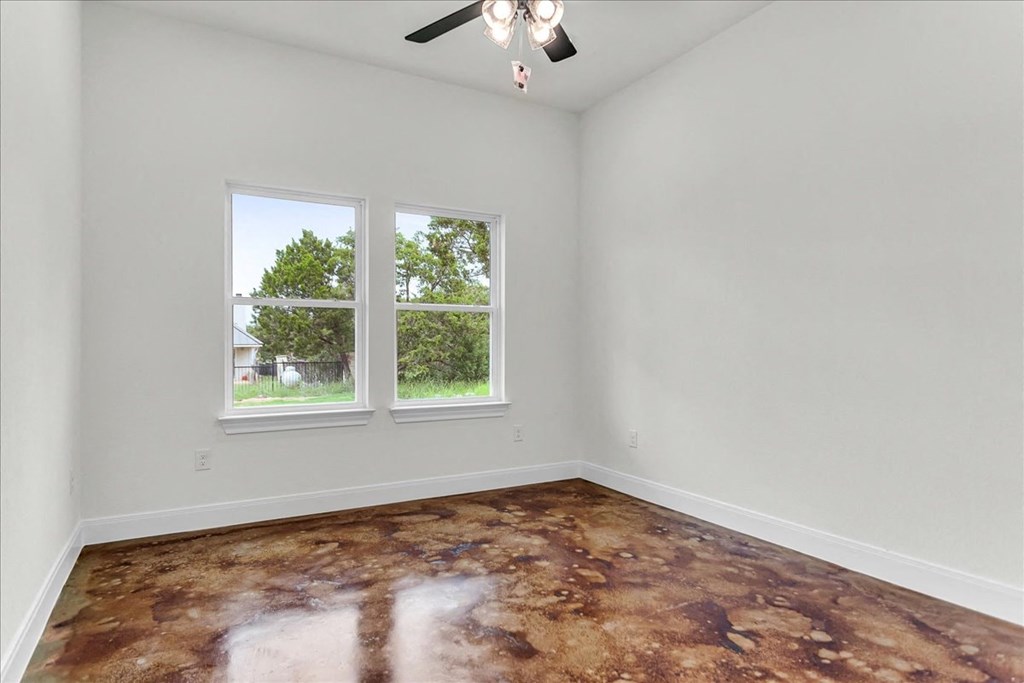 an empty room with a window and a brown floor