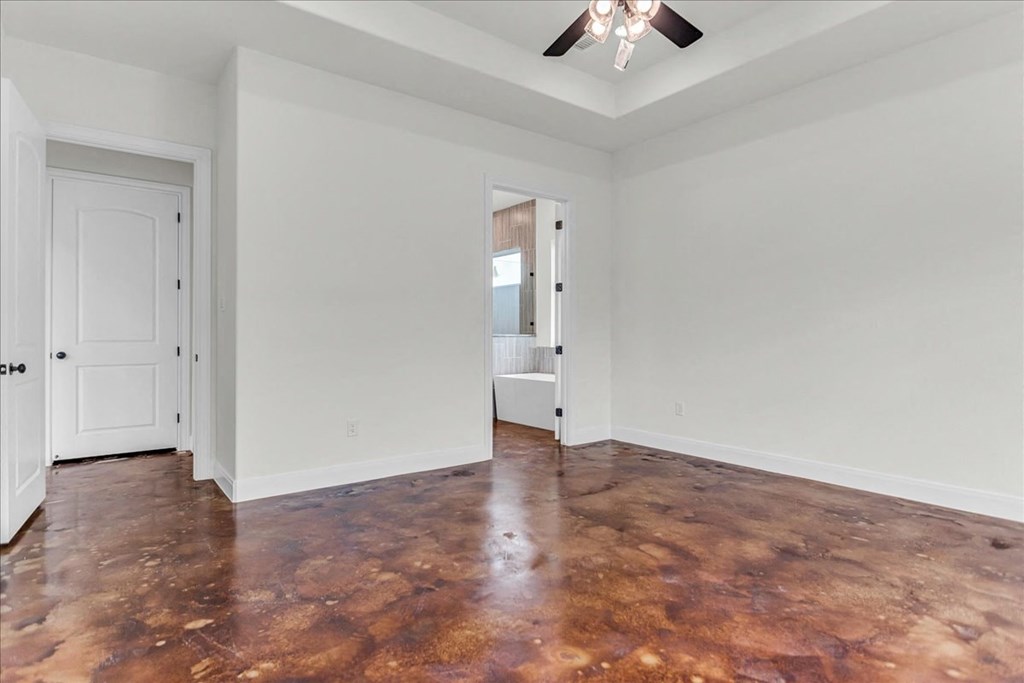 an empty living room with white walls and a ceiling fan