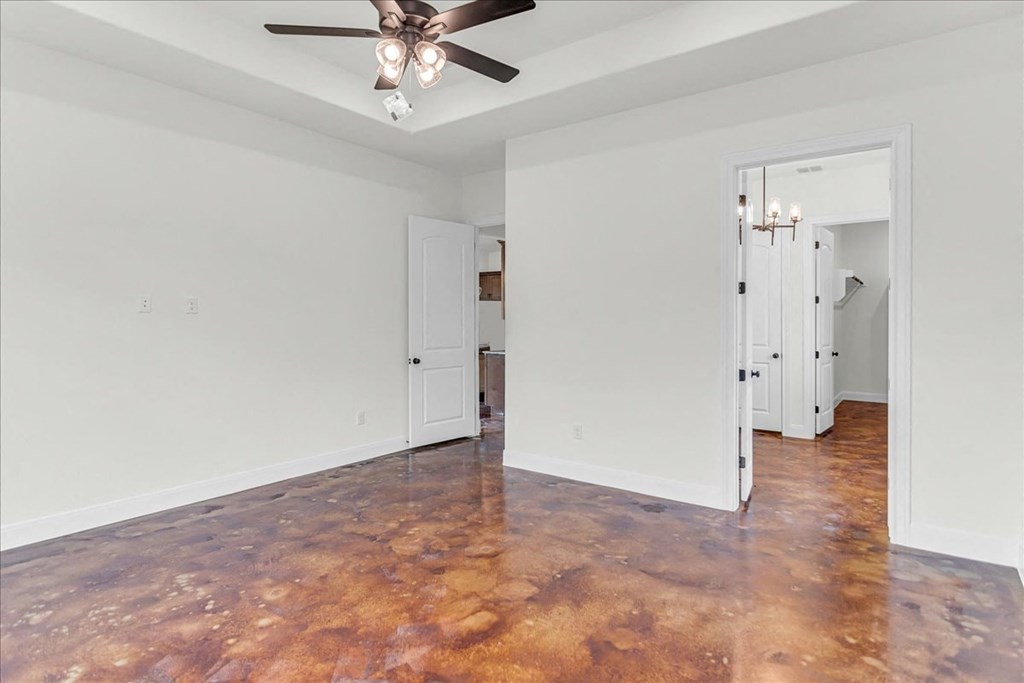 an empty living room with white walls and a ceiling fan