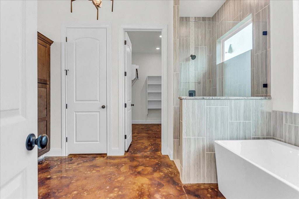 a bathroom with a tub and a shower and a door
