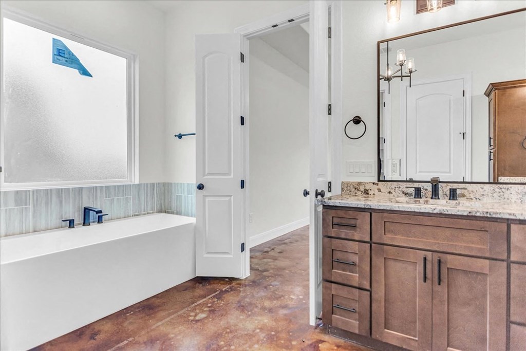 a bathroom with wooden cabinets and a tub and a sink