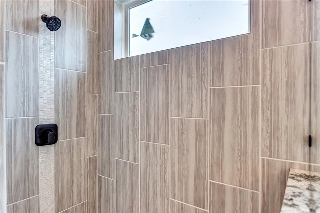 a large shower with wood tile in a bathroom