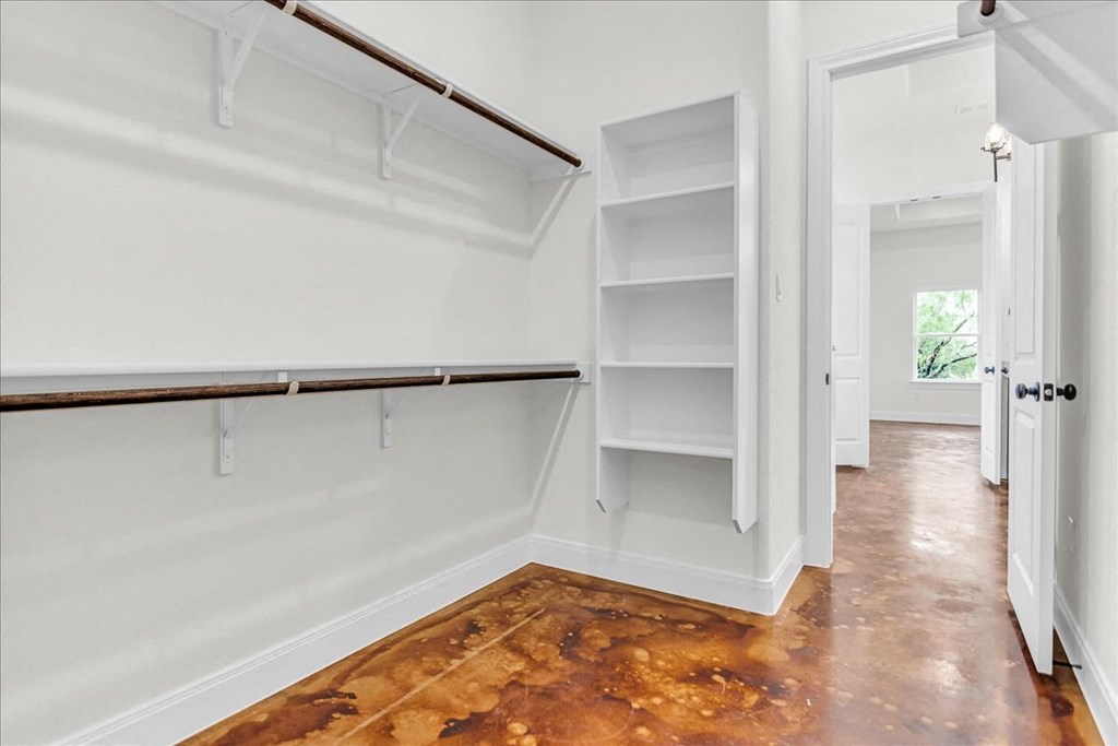 a room with white walls and a closet with shelves