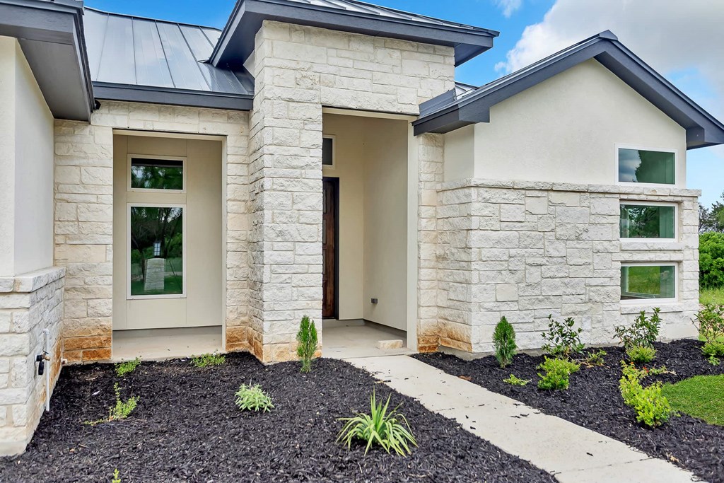 a new home with a pathway and stone facade