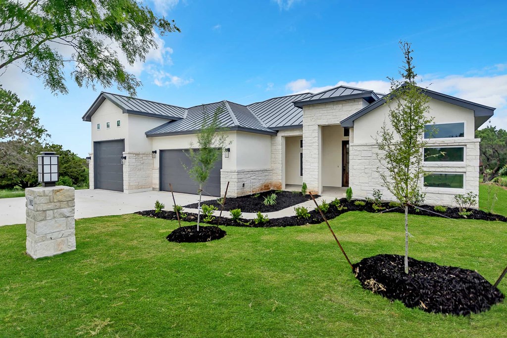a white house with a lawn and trees