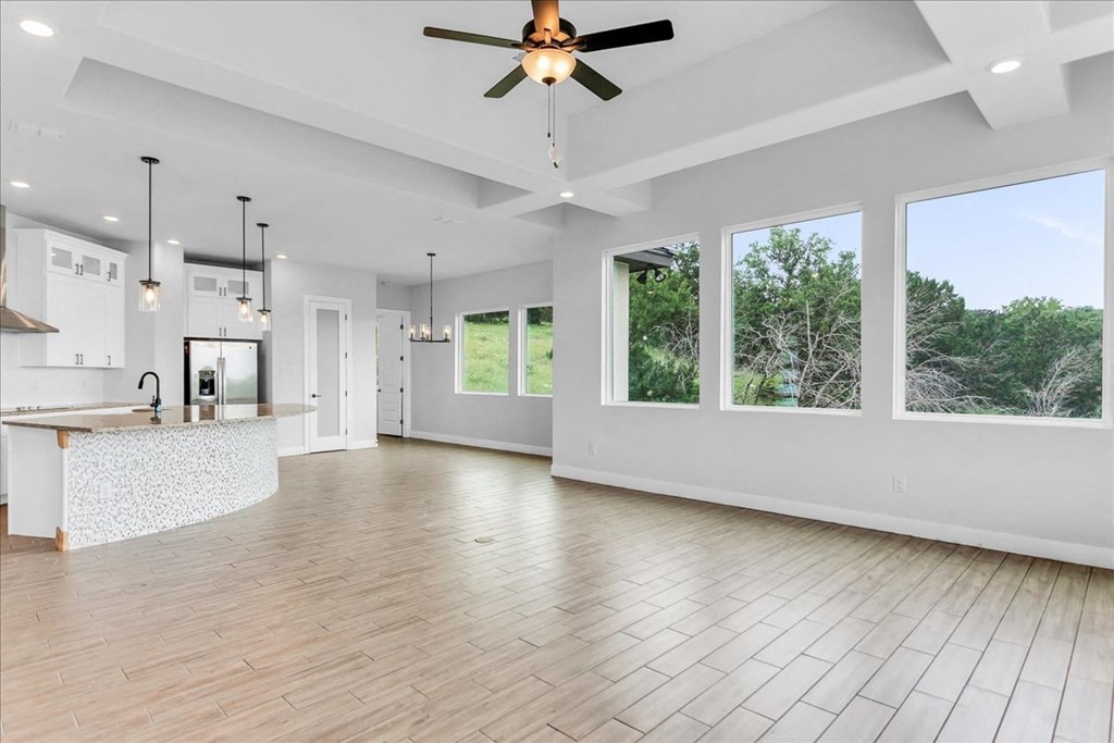 a large living room with a kitchen and a ceiling fan