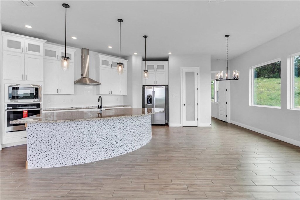 a white kitchen with a large island in the middle