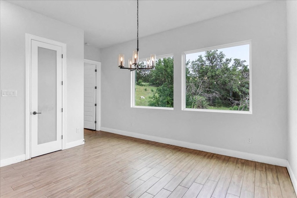 an empty living room with two windows and a door