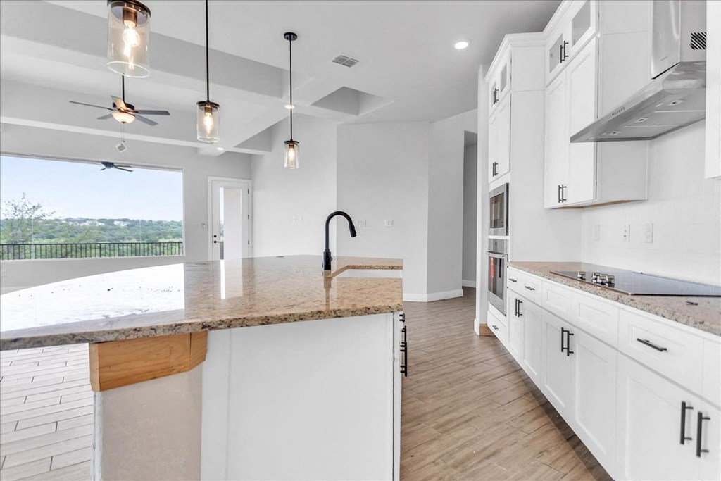 an open kitchen with white cabinets and a counter top