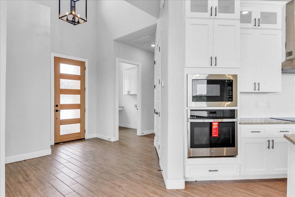 a kitchen with white cabinets and a stove and a microwave