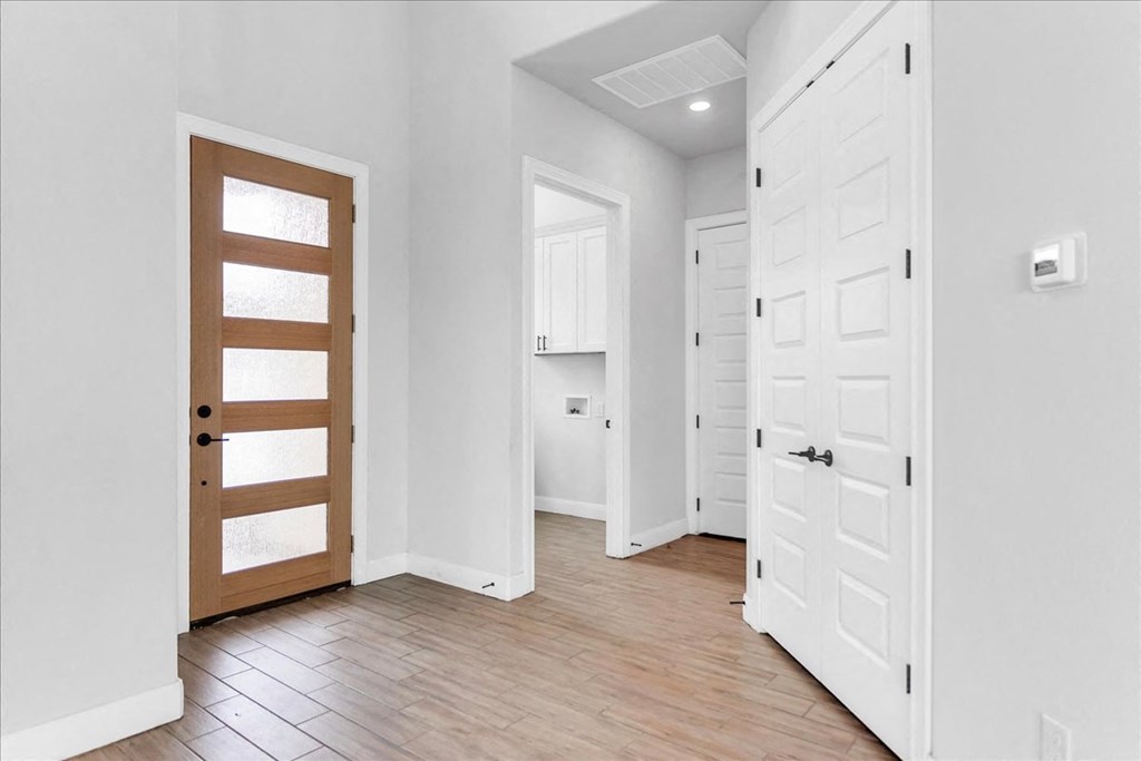a bedroom with a door to a bathroom and a closet