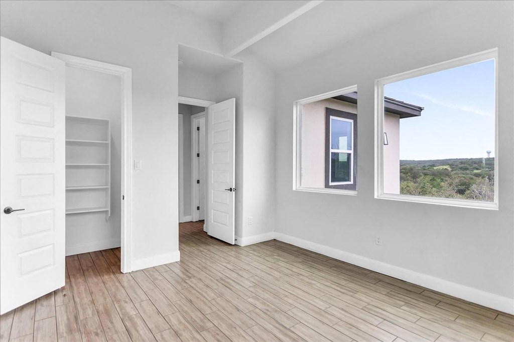 a living room with white walls and a window and a door