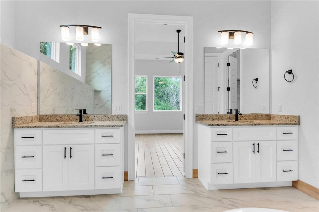a white bathroom with two sinks and a mirror