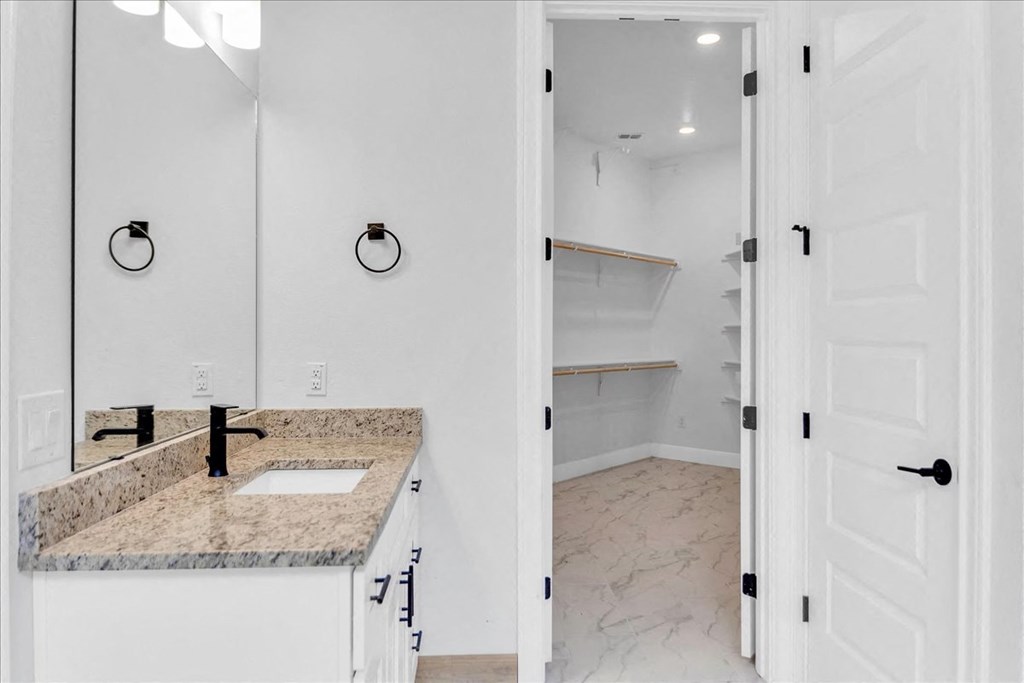 a white bathroom with a sink and a mirror