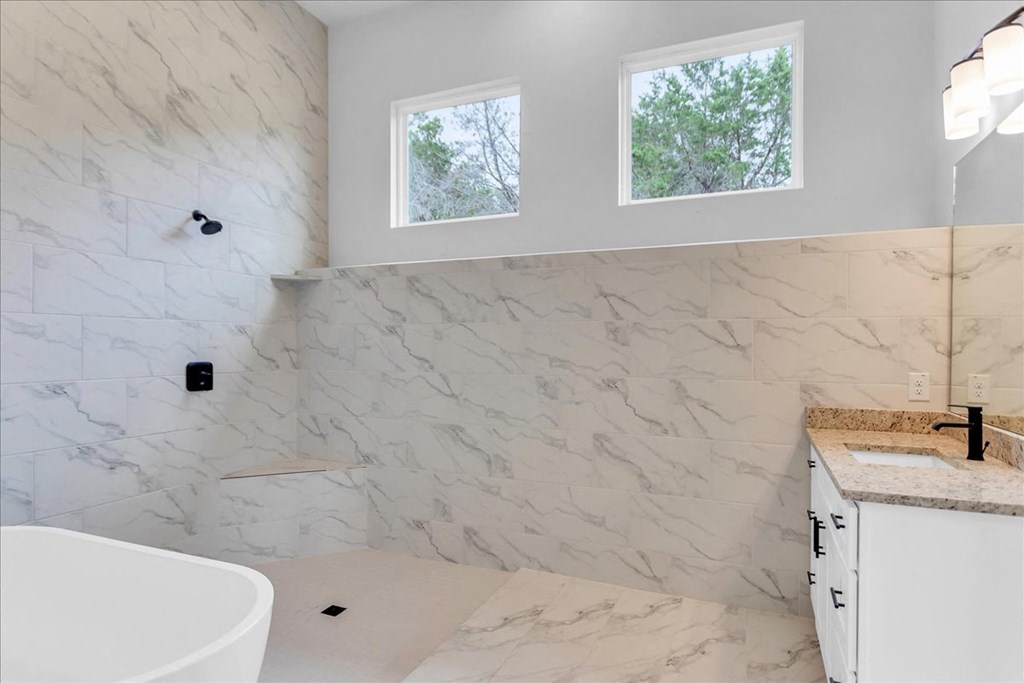 a bathroom with a tub and a sink and a window